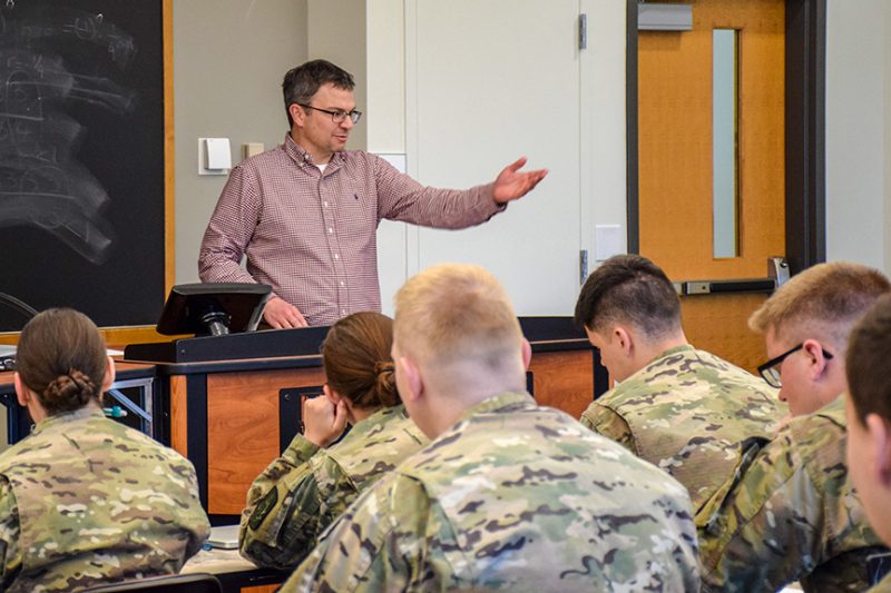 A businessman talks with a group of cadets.