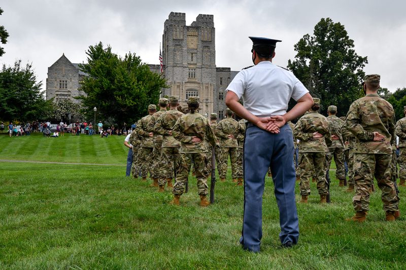 Cadets in formation during a parade on the Drillfield with Burruss Hall in the background.